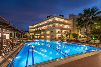 a pool in front of a hotel at night at Mirtilos Studios & Apartments in Kissamos