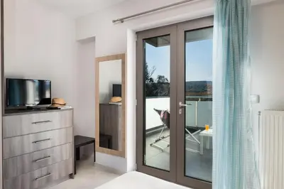 a room with a sliding glass door leading to a balcony at Jasmine in Maleme