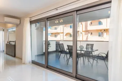 a dining room with glass doors and a table at Jasmine in Maleme