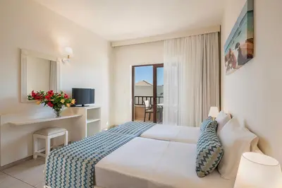 a hotel room with a bed and a balcony at Indigo Mare in Plataniás