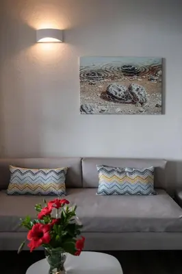 a living room with a couch and a vase with flowers at Alianthos Suites in Tersanas