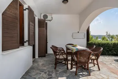 a dining room with a table and chairs on a patio at Alianthos Suites in Tersanas