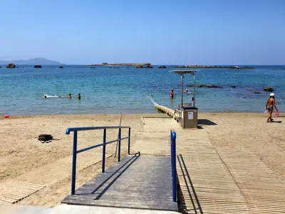 a beach with people swimming in the water at Nea Chora Maisonette in Chania Town