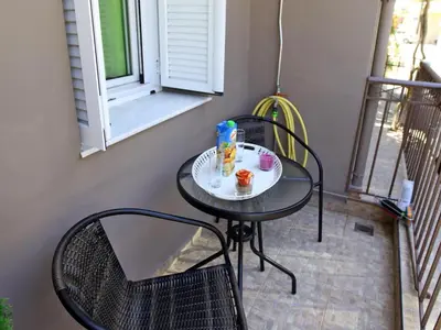 a small table and chairs on a balcony at Nea Chora Maisonette in Chania Town