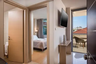 a hotel room with a bed and a balcony at Trianon Luxury Apartments & Suites in Chania Town
