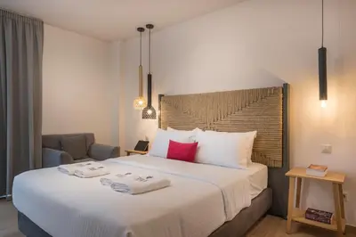 a bedroom with a large bed with two towels on it at Trianon Luxury Apartments & Suites in Chania Town
