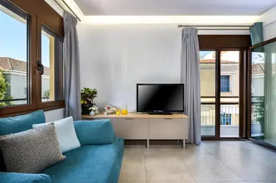 a living room with a blue couch and a tv at City Breeze Apartment in Chania Town