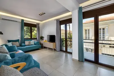 a living room with a blue couch and a tv at City Breeze Apartment in Chania Town