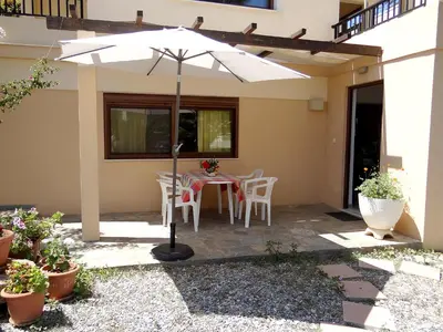 a patio with an umbrella and a table and chairs at Apartment by the Sea in Kato Daratso