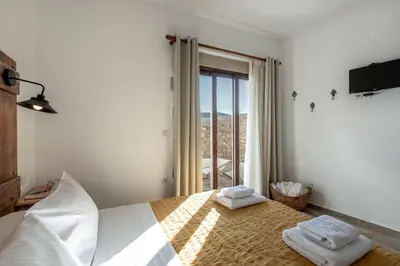 a bedroom with a bed with two towels on it at Villa Aerino in Azoyirás