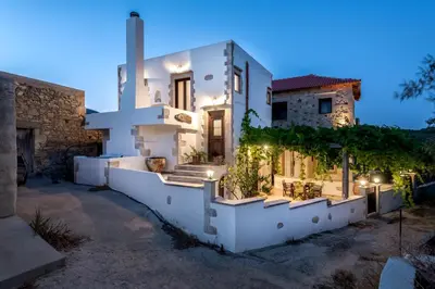 a white house with a courtyard at night at Villa Aerino in Azoyirás
