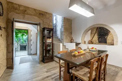 a kitchen with a table and chairs and a staircase at Villa Aerino in Azoyirás