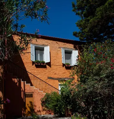 a orange building with two windows and a staircase at Casa Arokaria in Pendarianá
