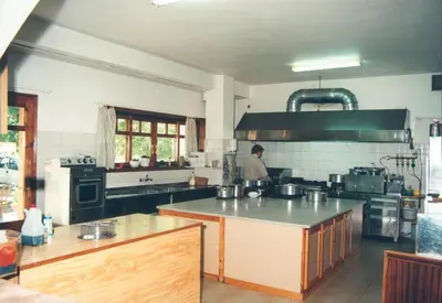 a kitchen with a person standing in the kitchen at Neos Omalos Hotel in Omalós