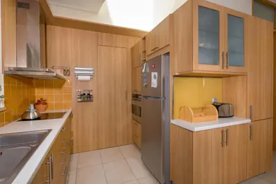 a kitchen with wooden cabinets and a stainless steel refrigerator at Gea Maleme in Maleme