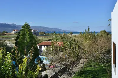 a view of a yard with trees and a building at San Antonio Apartments in Kolymvari