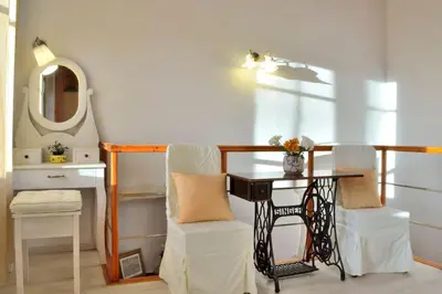 a room with a table and a chair and a mirror at Charming stone corner house in Chania Town