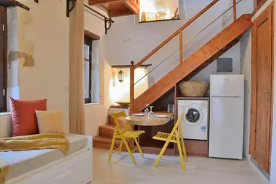 a living room with a table and a washer and dryer at Charming stone corner house in Chania Town