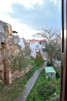 a view from a window of a street with a green bench at Charming stone corner house in Chania Town