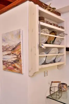 a white cabinet with plates and dishes in it at Charming stone corner house in Chania Town