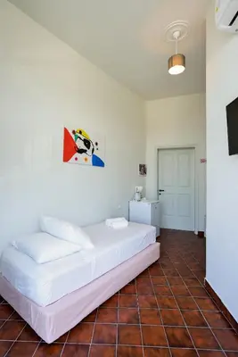 a bedroom with a white bed and a tiled floor at Loucerna Suites Chania in Chania Town