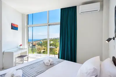 a bedroom with a bed and a large window at Loucerna Suites Chania in Chania Town