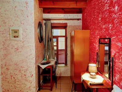 a red room with a table and a mirror at Caza Latina in Chania Town