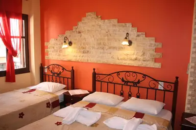 two beds in a room with orange walls at MmeBassia in Chania Town