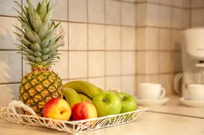 a basket of fruit on a counter with a pineapple at Sea Daffodil apartments in Kissamos
