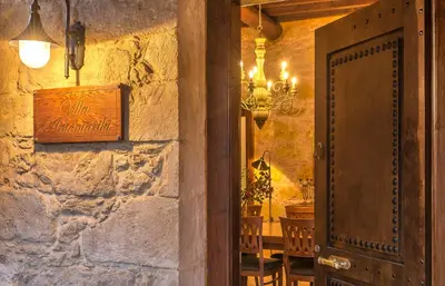 a room with a stone wall with a table and a door at Villa Arhontariki in Kissamos