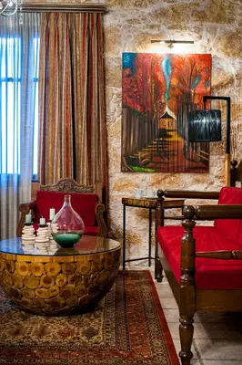 a living room with a red couch and a table at Villa Arhontariki in Kissamos