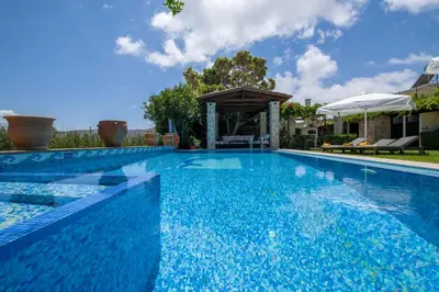 an infinity pool with a gazebo in a backyard at Villa Arhontariki in Kissamos