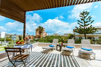a patio with a table and chairs and a view at Gregory Comfort Hotel in Kalamaki Chanion