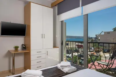 a bedroom with a bed and a view of a balcony at Nidus Villa in Souda