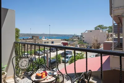a table with a bowl of fruit on a balcony at Nidus Villa in Souda