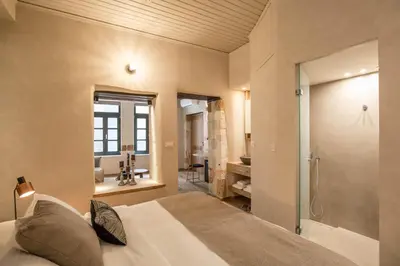 a bedroom with a bed and a bathroom with a shower at J&G Suites in Chania Town