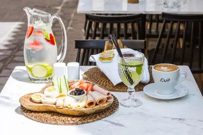 a table with a plate of food and a cup of coffee at J&G Suites in Chania Town