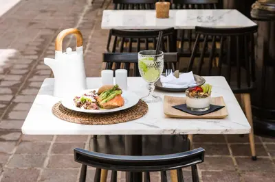 a white table with a plate of food on it at J&G Suites in Chania Town