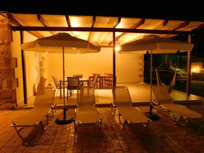 a group of chairs and umbrellas on a patio at Villa Leonton with a private pool in Kissamos