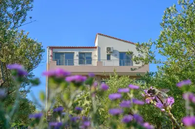 a house with purple flowers in front of it at Bee House in Kissamos