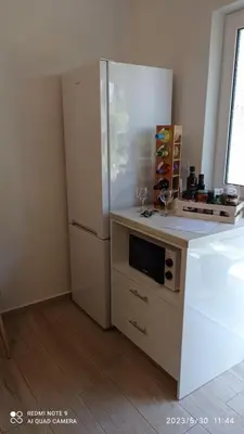 a kitchen with a refrigerator and a microwave at Sunshine Apartments in Kato Daratso