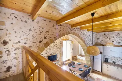 a kitchen and dining room with a wooden ceiling at Achilleas Apartments with Sea View in Kolymvari