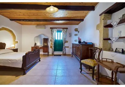 a bedroom with a bed and a table and a chair at Achilleas Apartments with Sea View in Kolymvari