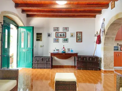 a living room with a green door and a table at Evaggelias Home Gavalochori in Gavalochori