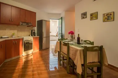 a kitchen with a table with chairs and a refrigerator at Evaggelias Home Gavalochori in Gavalochori