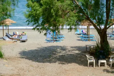 a group of people laying on chairs on a beach at Seafront Paradise steps to Beach in Plataniás
