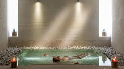 a woman laying in a swimming pool with candles at Avra Imperial Hotel in Kolymvari