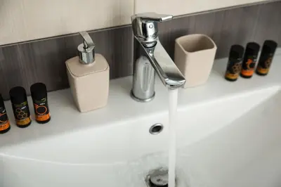 a bathroom sink with a faucet and some bottles at Dreamy Holidays Apartment in Chania Town