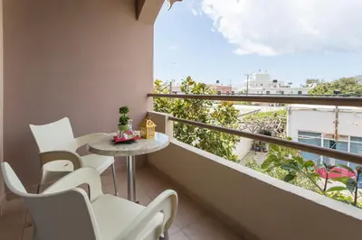 a balcony with a table and chairs and a large window at Glaros Hotel in Palaiochóra