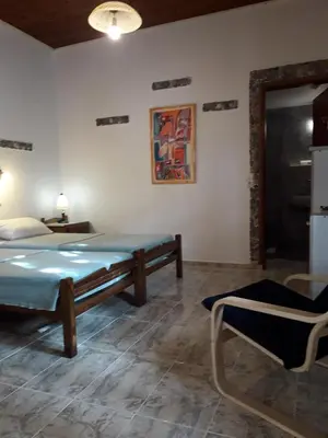 a bedroom with a bed and a table and a chair at Beach Studio next to the center in Kissamos